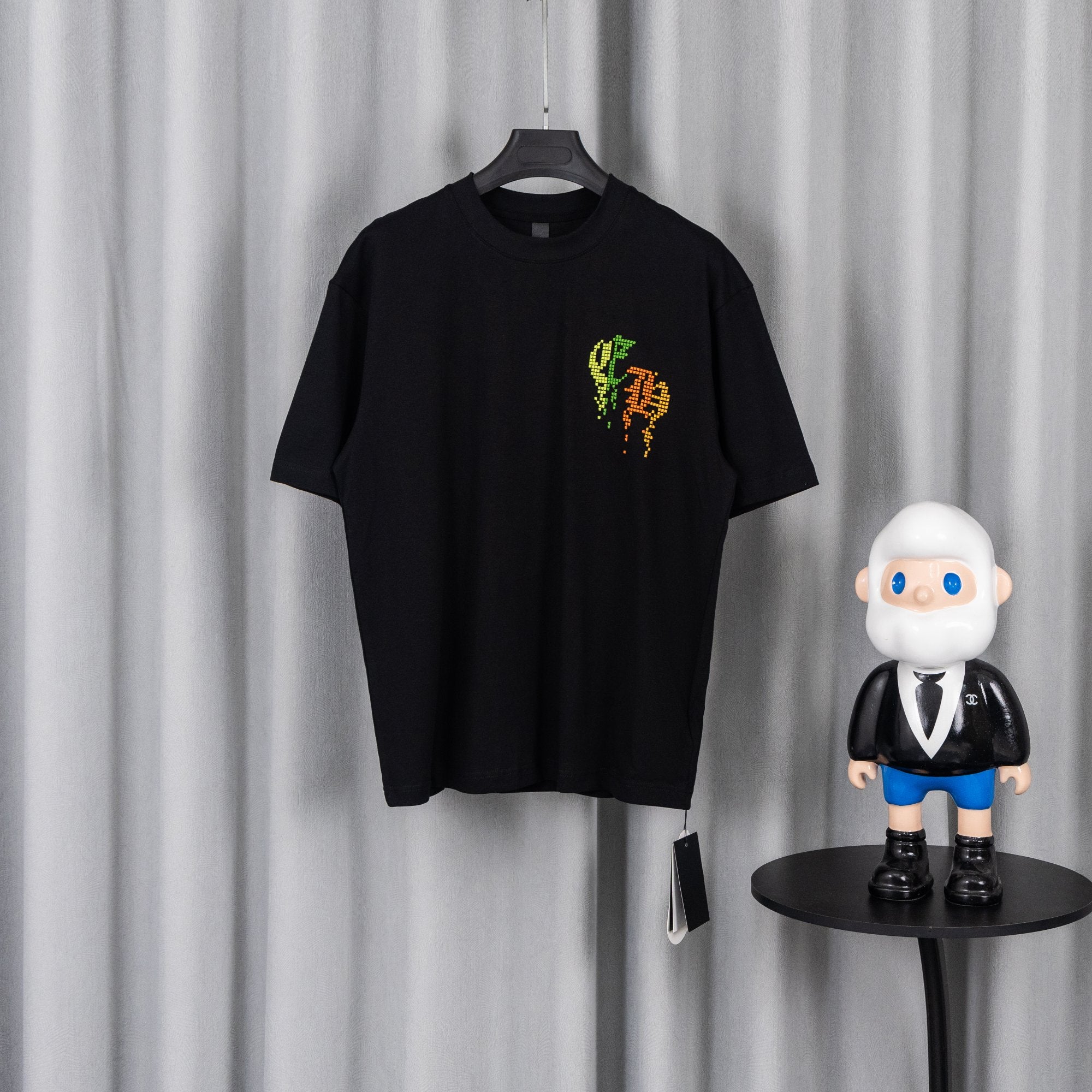 Black short-sleeve T-shirt with neon pixel logo on chest.