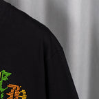 Black short-sleeve T-shirt sleeve with partial neon graphic detail.