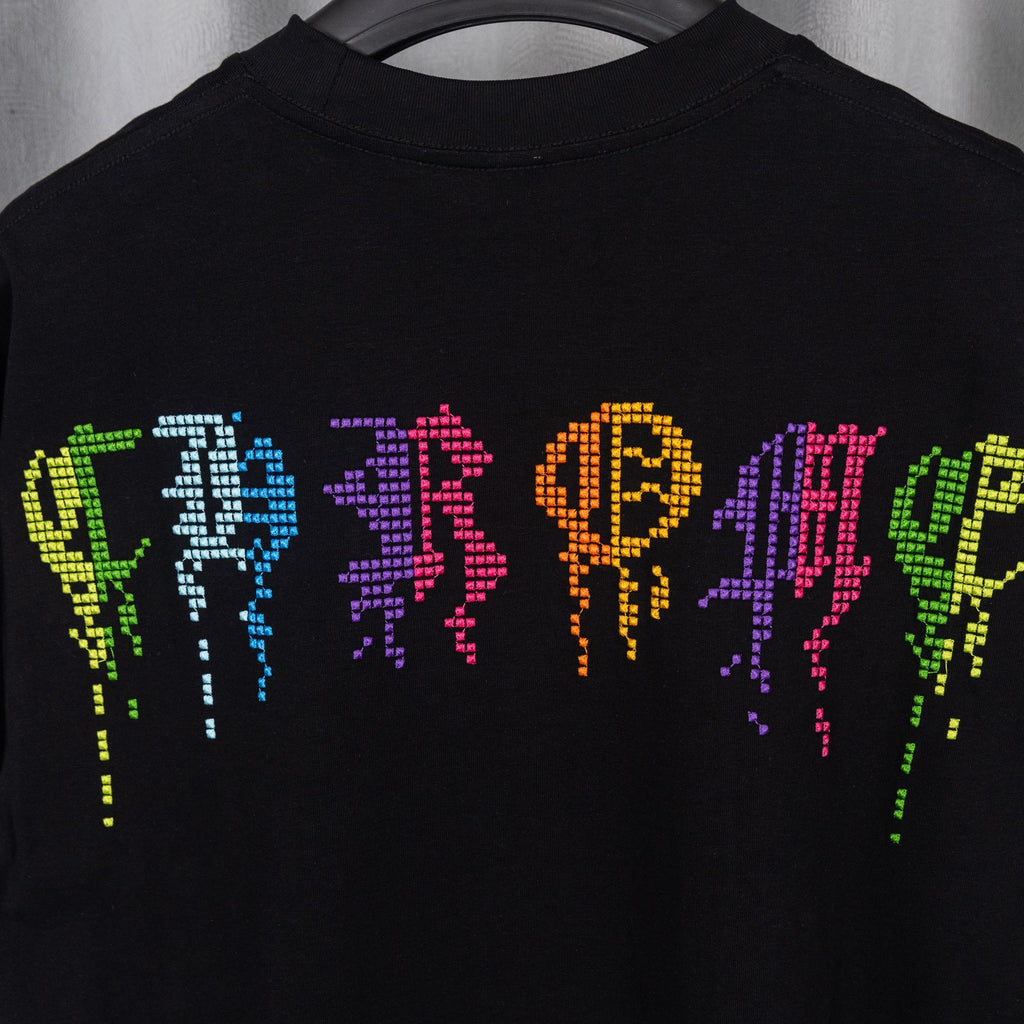 Black T-shirt close-up of neon pixel graphic on chest.