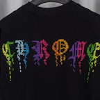 Black T-shirt close-up of neon pixel graphic on chest.