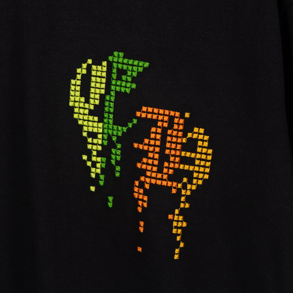 Black T-shirt chest print with neon green and orange pixel graphic.