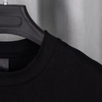 Black T-shirt neckline with black label at collar seam.