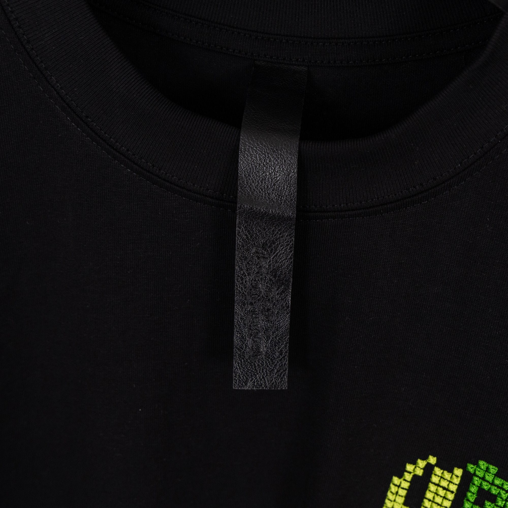 Black T-shirt collar with interior neck label tab.