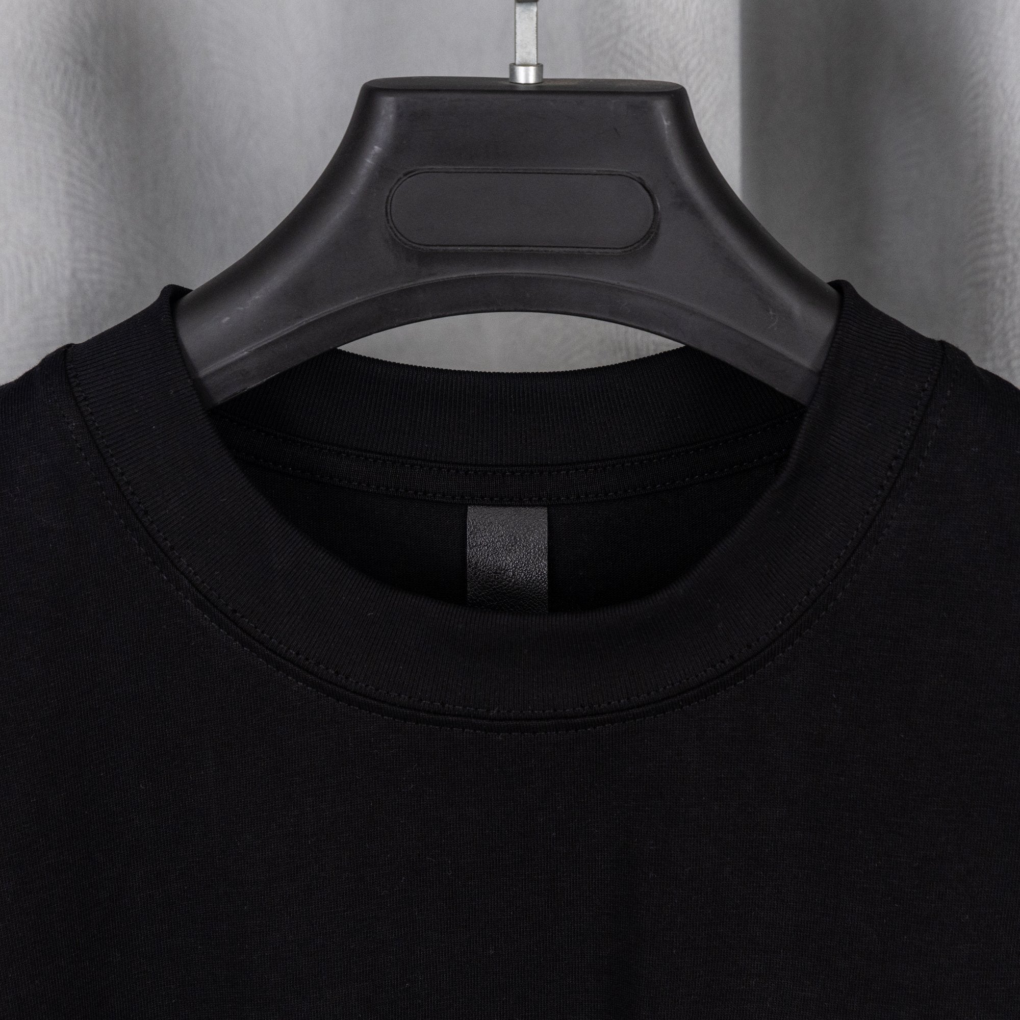 Black crewneck T-shirt with ribbed collar and short sleeves
