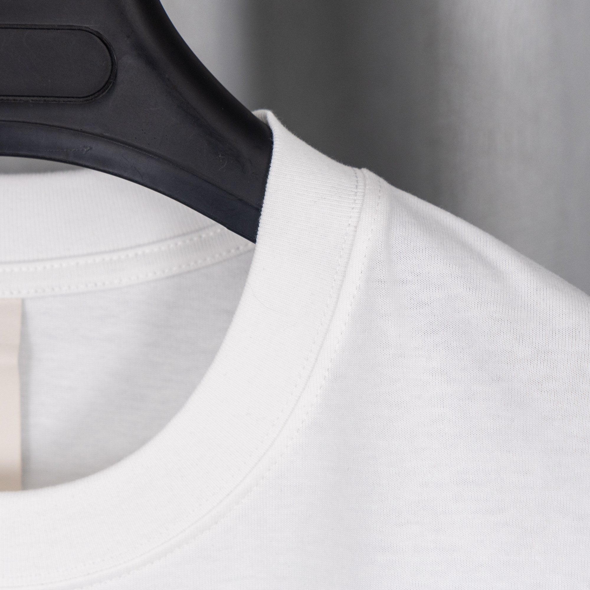 White T-shirt neckline with black shoulder/collar trim and stitching