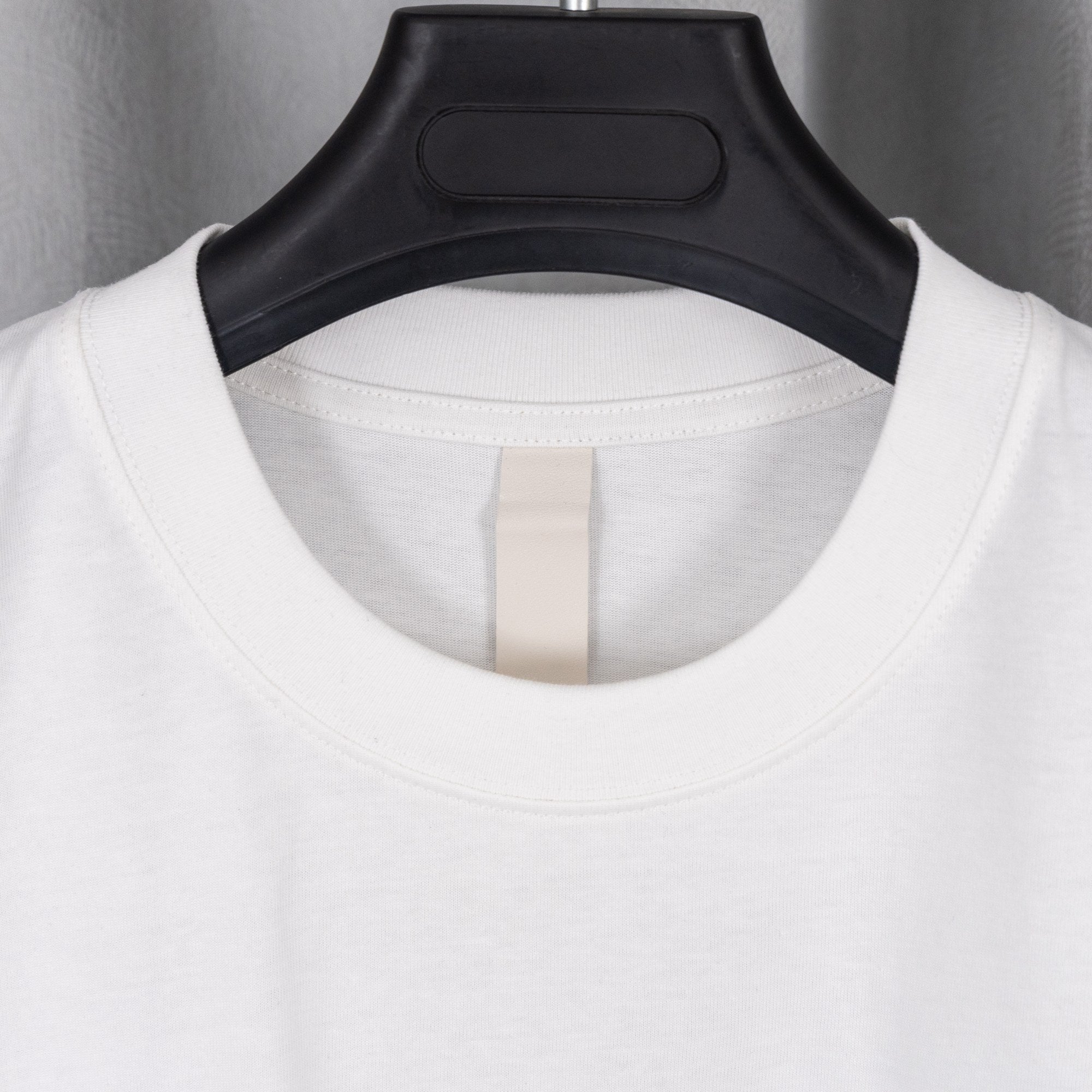 White crewneck T-shirt with black collar trim and neck label detail