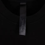Black T-shirt neck label with fabric tag at inner collar