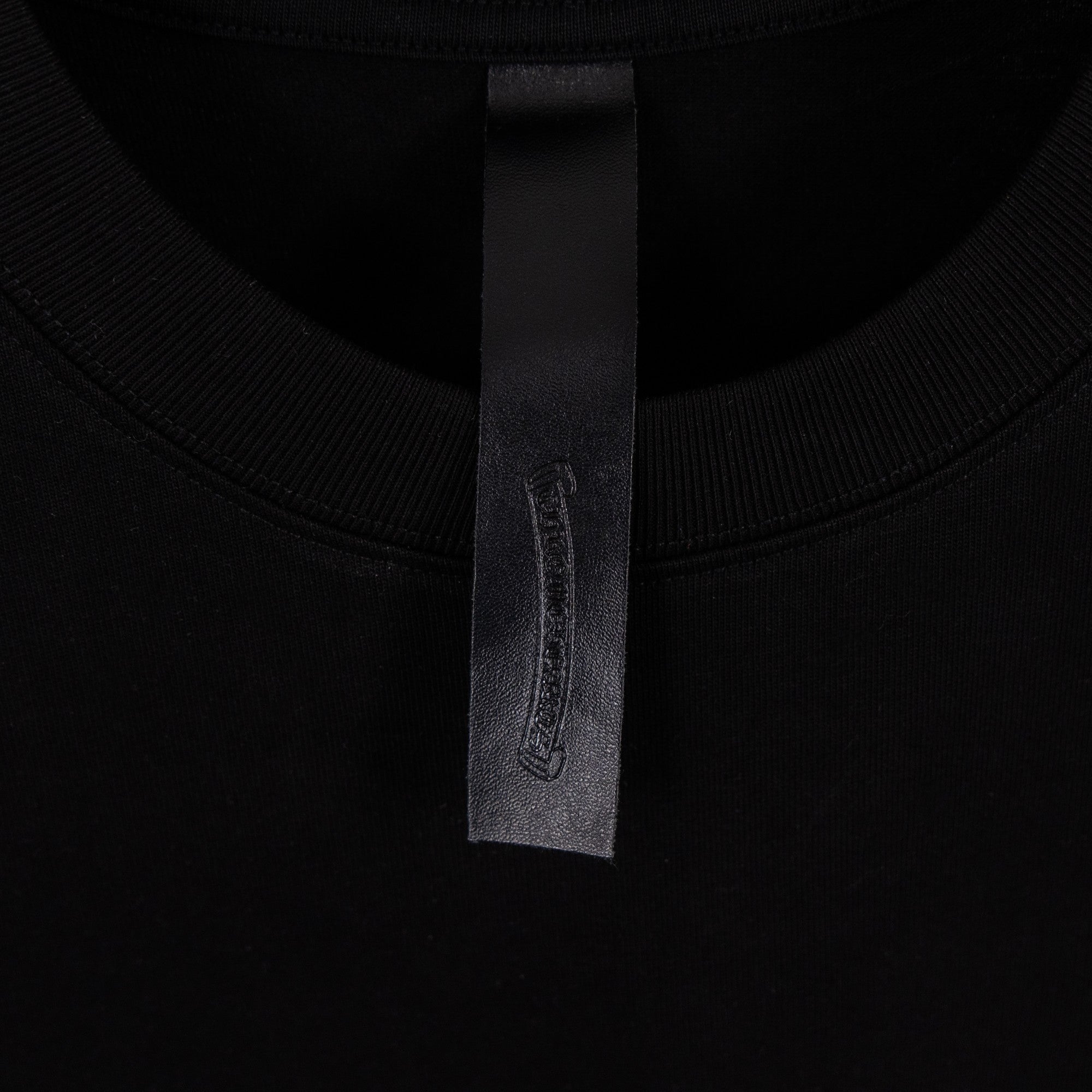 Black T-shirt neck label with fabric tag at inner collar