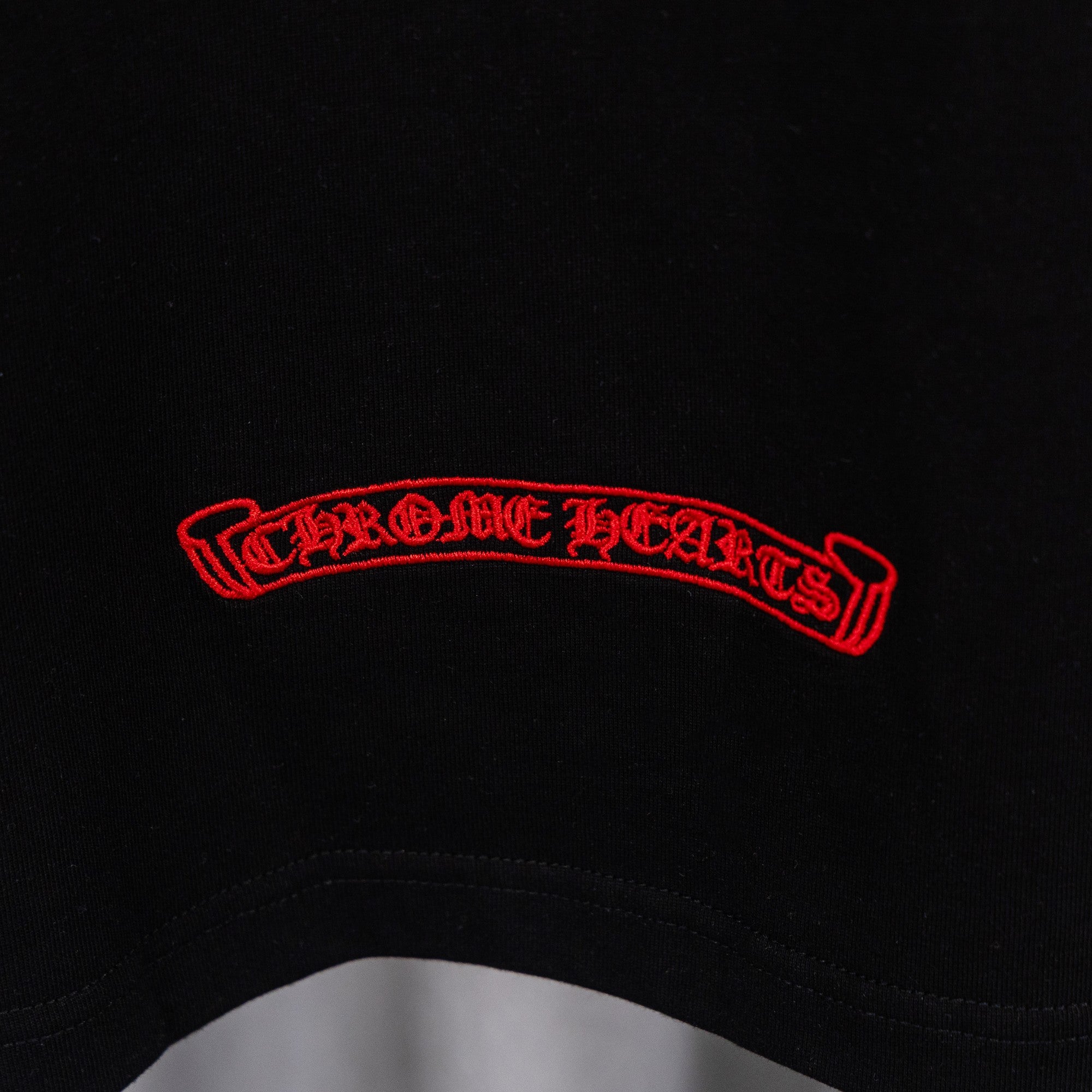 Black T-shirt with red curved text logo across chest