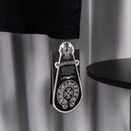 Black T-shirt with hanging product tag and chain near hem