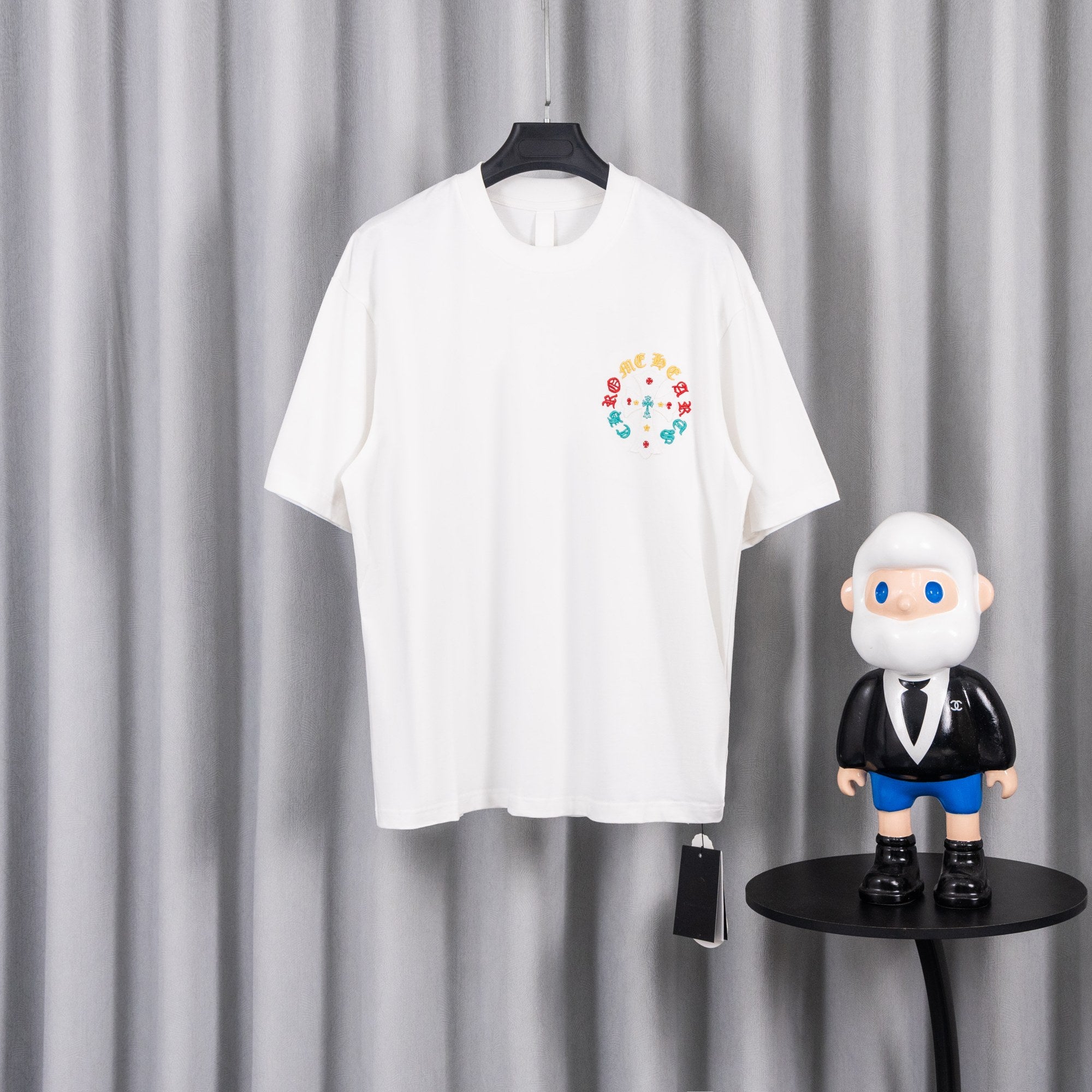 White short-sleeve T-shirt with colorful circular graphic on chest.