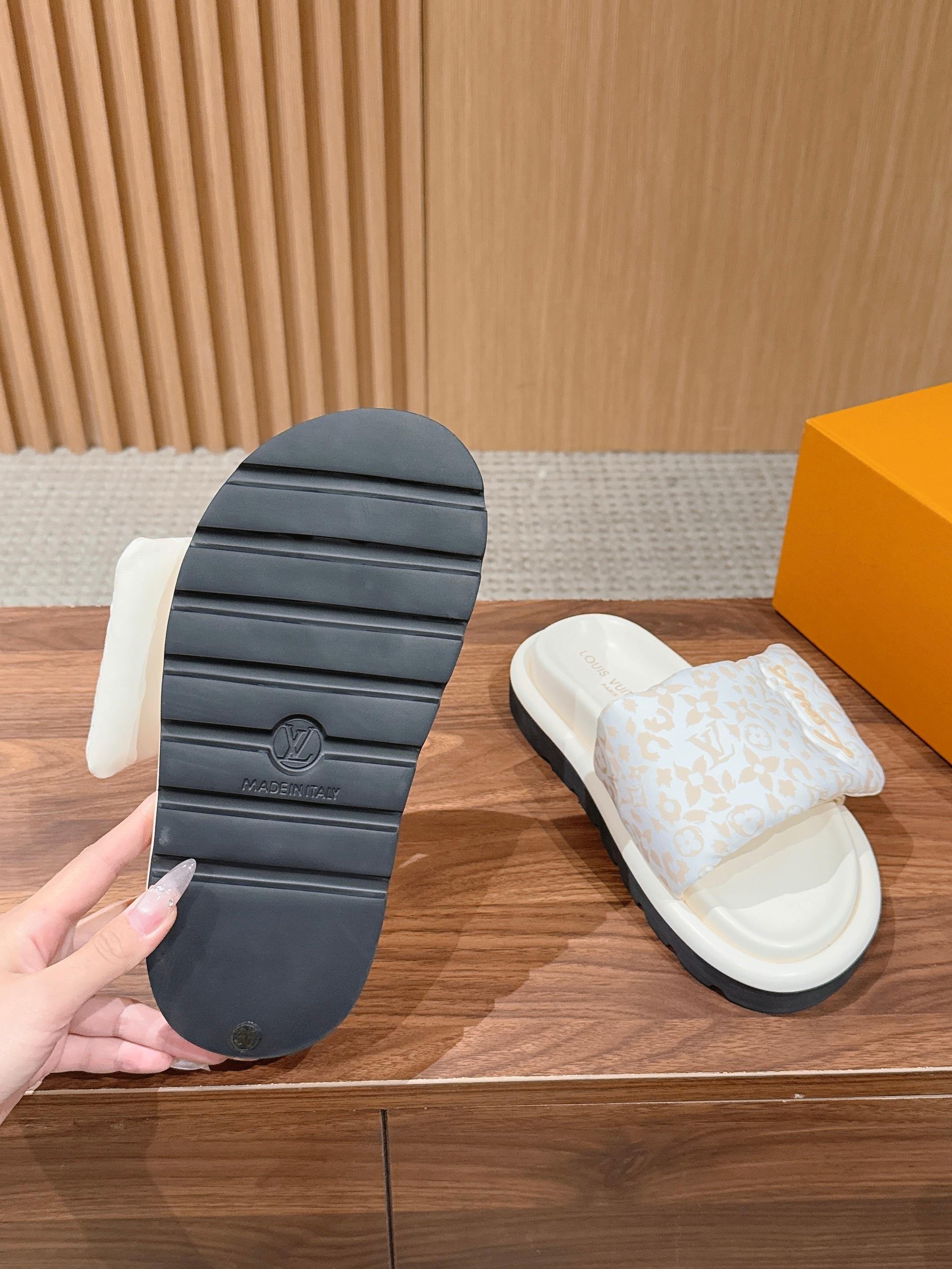 White Louis Vuitton monogram slide sandals with detailed tread on rubber outsole