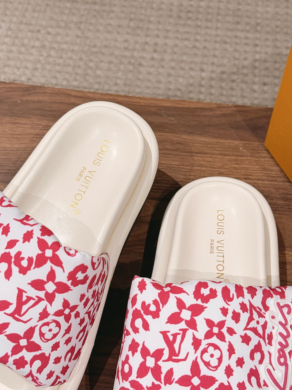 Pair of pink floral logo-pattern slide sandals with white insoles and gold lettering