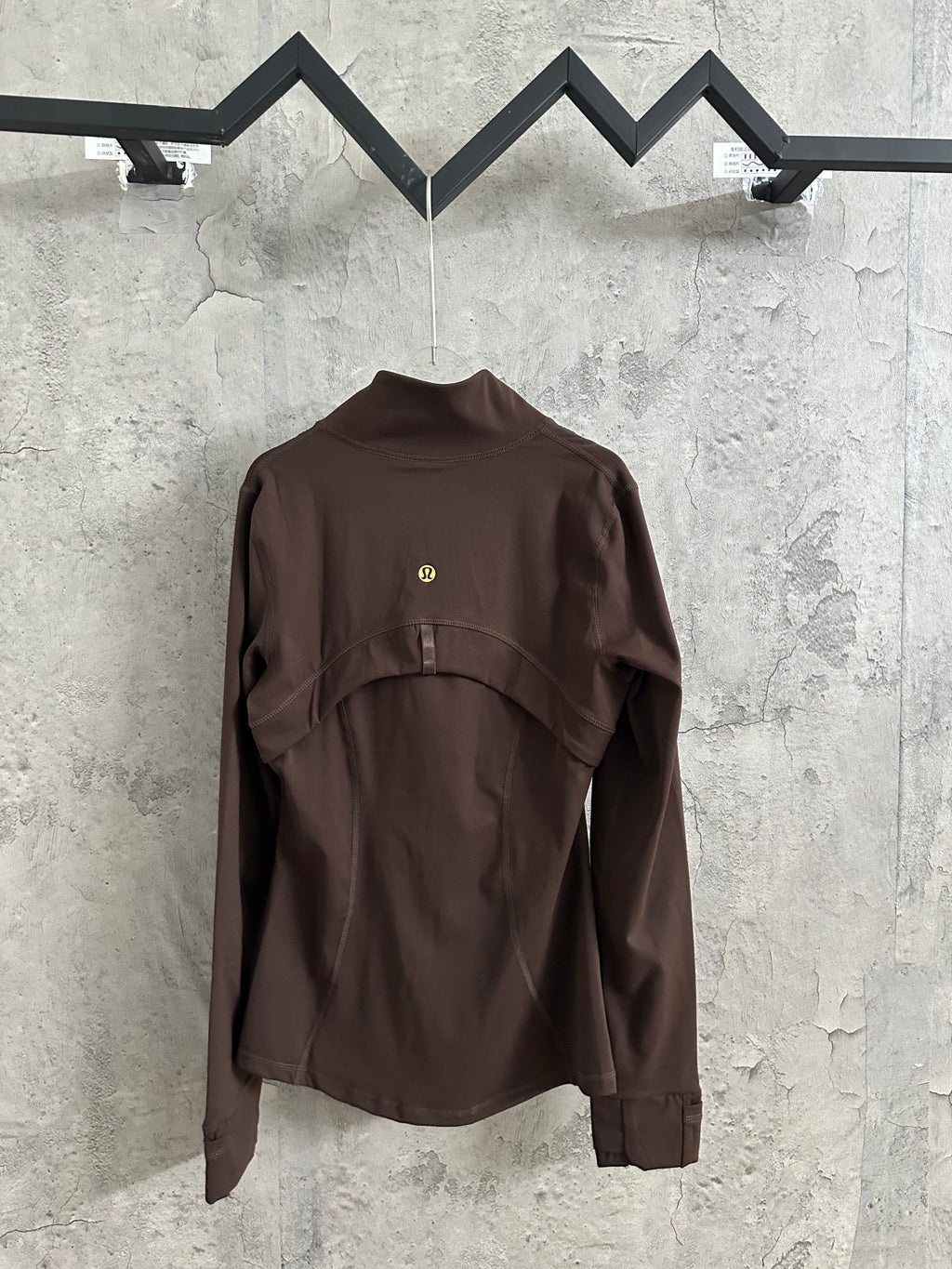 Brown zip-up jacket with stand collar and curved front yoke seams, hanging display