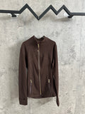 Brown zip-up jacket with stand collar and gold-tone front zipper, hanging on a rack