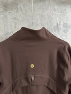 Brown jacket back neckline with small logo emblem near upper chest
