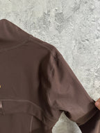 Brown jacket shoulder and sleeve with curved seam stitching near the collar