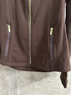 Brown jacket front with gold-tone zip pull and two zip pockets at sides