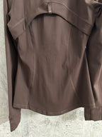 Brown jacket back with yoke seams and relaxed fit; cuff details visible