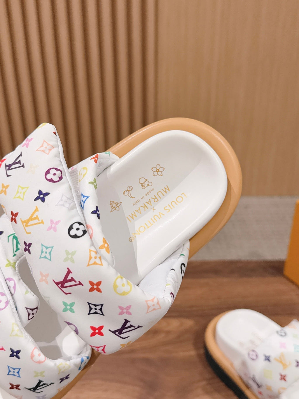 Louis Vuitton sandal close-up, white slide band with multicolor monogram pattern