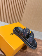 Slide sandals on black sole with multicolor logo strap, shown with box