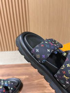 Slide sandals close-up: black sole with multicolor logo strap detail