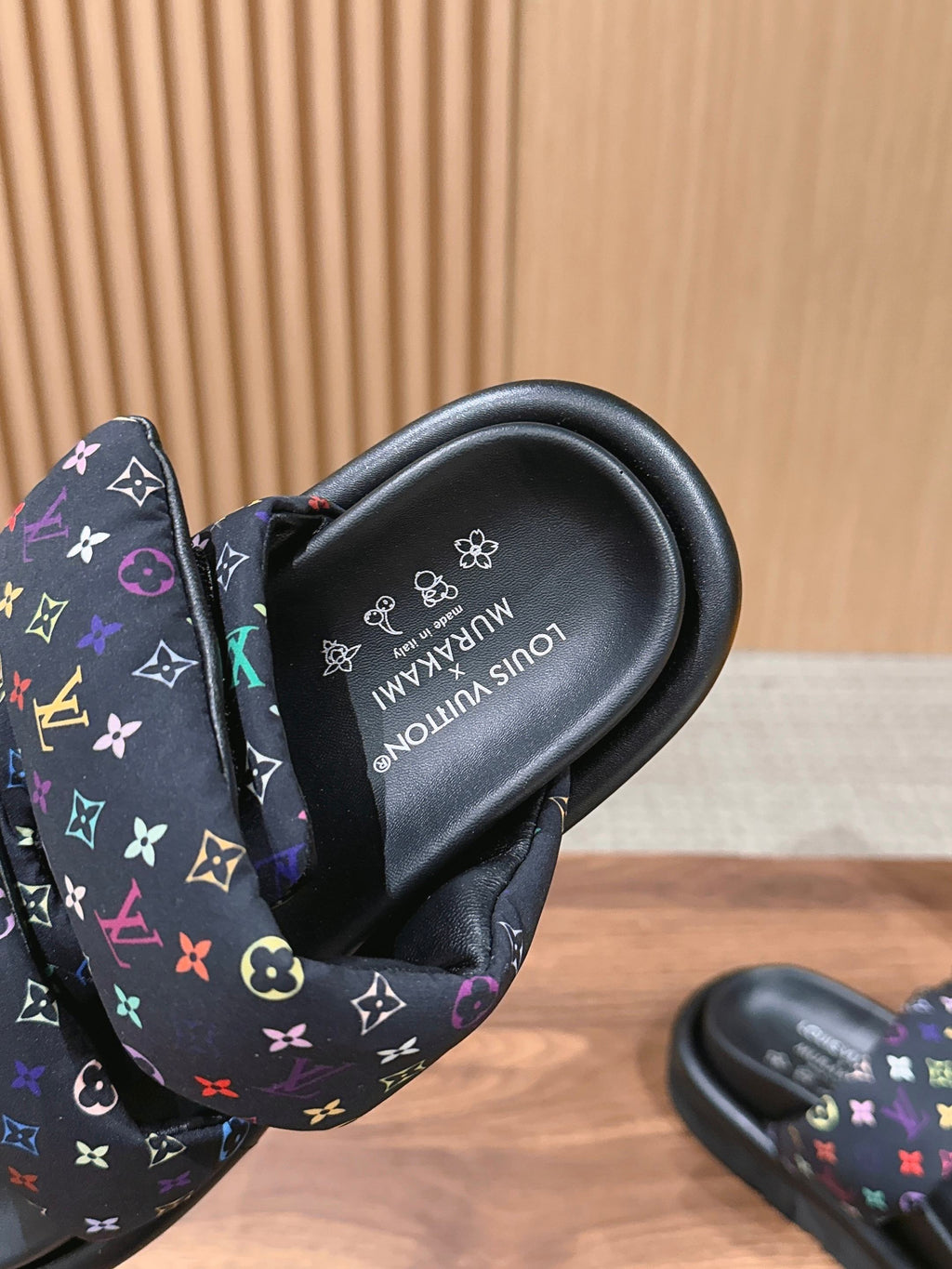 Slide sandals close-up: black insole with logo text and multicolor strap