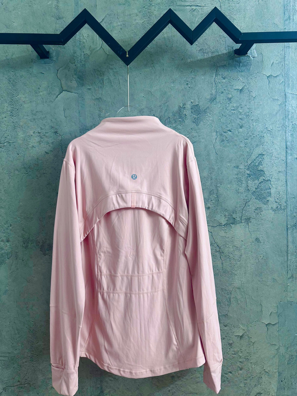 Light pink zip-up jacket with stand collar and small back logo