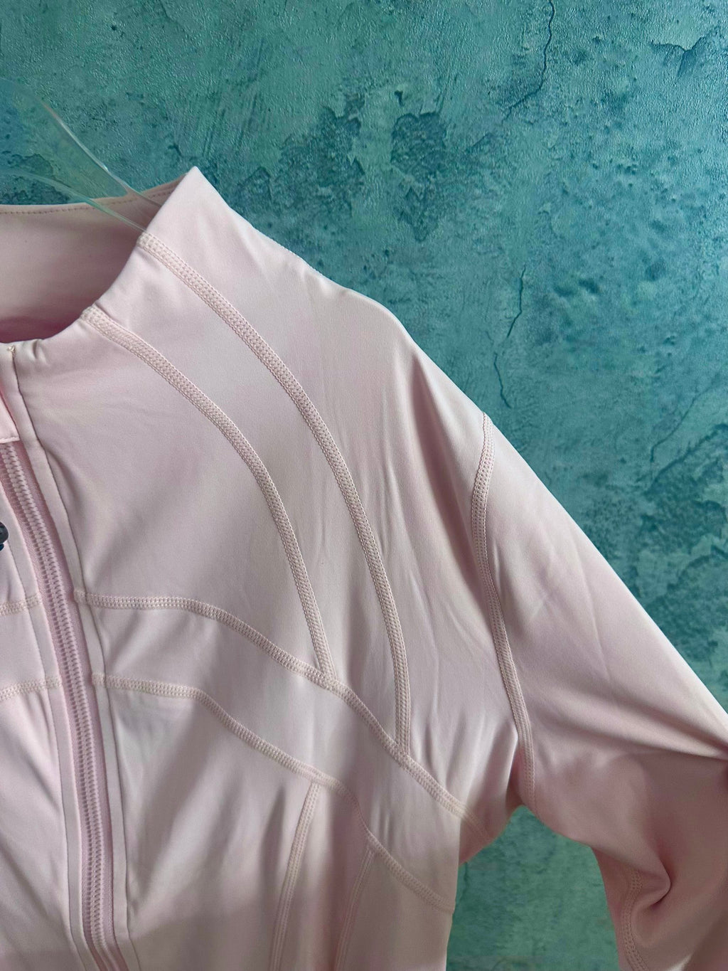 Light pink zip-up jacket sleeve with embroidered seam panels