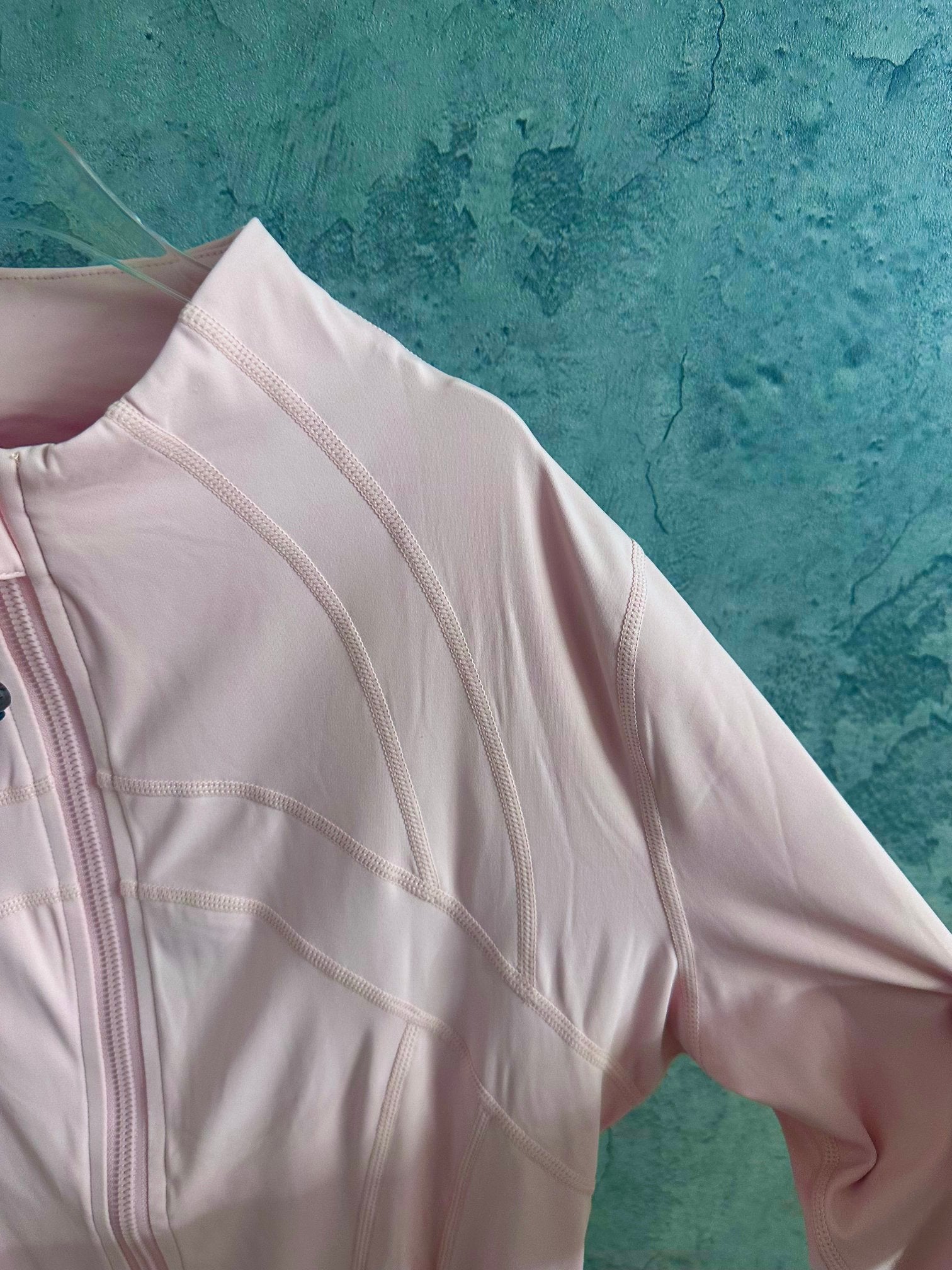 Light pink zip-up jacket sleeve with embroidered seam panels