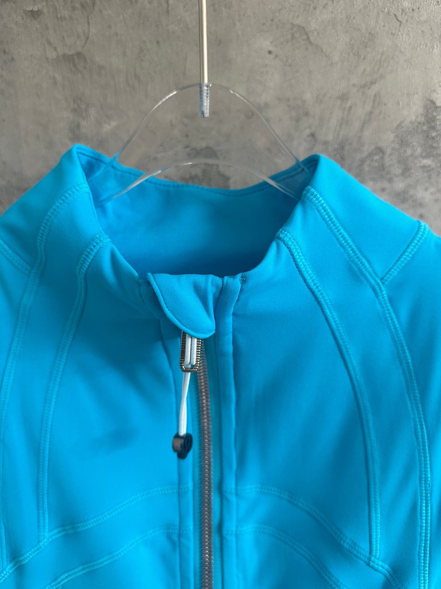 Light blue jacket showing front zipper and close-up of collar seam