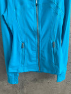 Light blue jacket front with full-length zipper and two chest pockets
