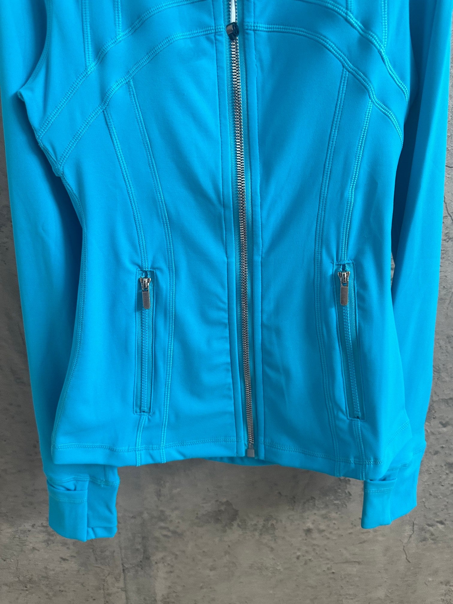 Light blue jacket front with full-length zipper and two chest pockets