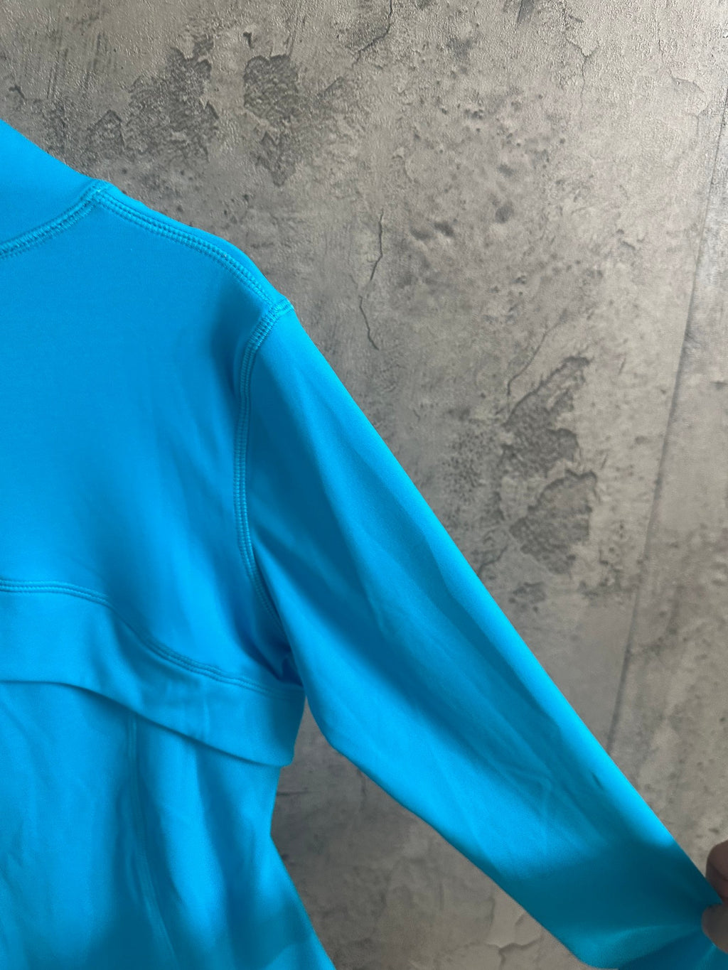 Light blue jacket shoulder and sleeve with stitched seam detail