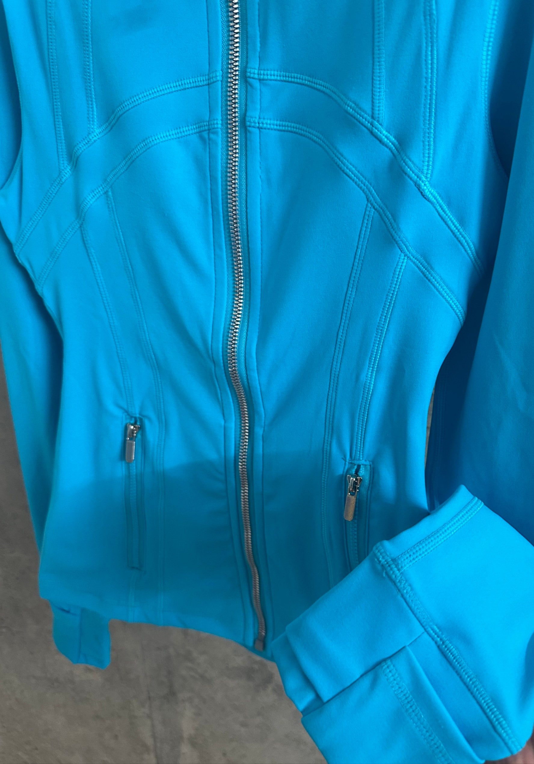 Light blue jacket close-up with front zipper and side pocket zippers