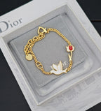 Gold-tone charm bracelet with bird charms and red enamel heart on cushion
