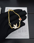 Gold-tone charm bracelet with bird charms and red enamel accents