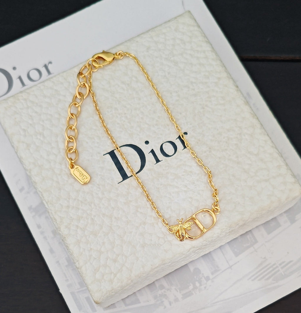 Gold-tone chain bracelet with Dior lettering and charm on white box insert