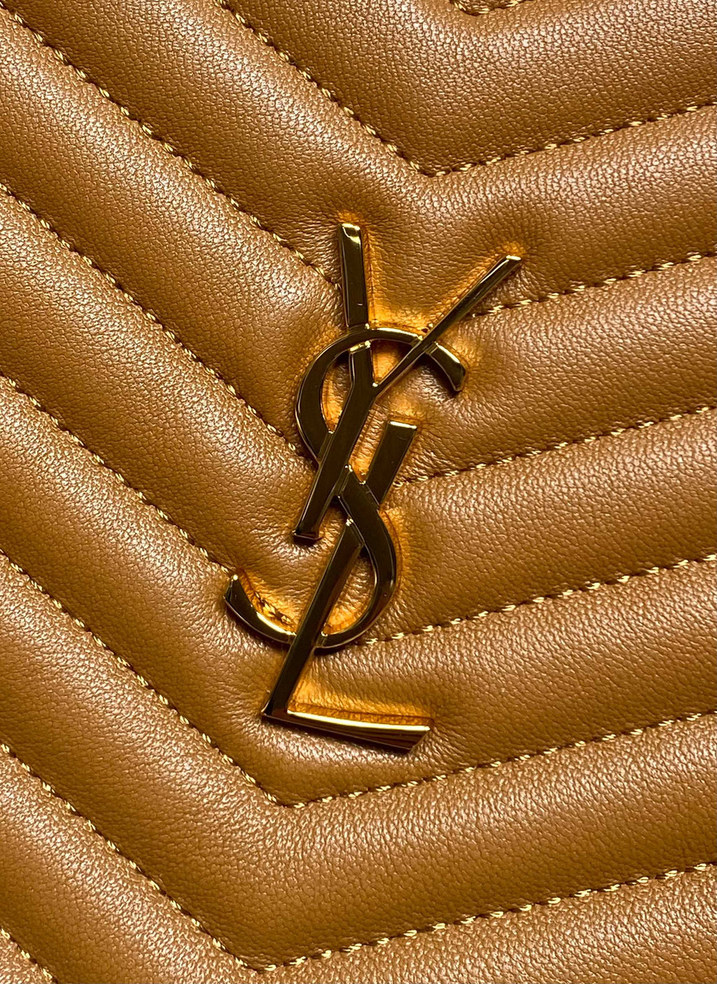 YSL gold-tone logo emblem on tan quilted leather panel