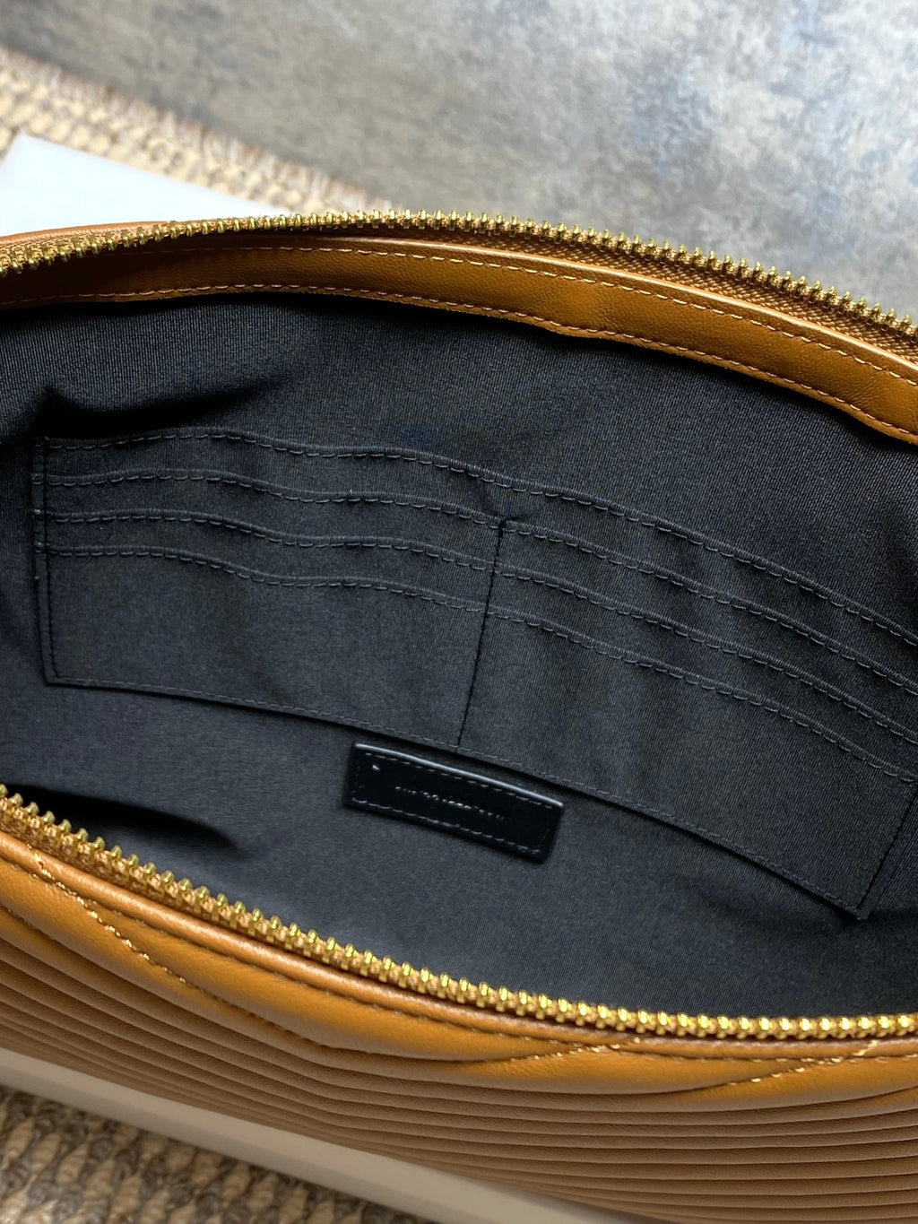 Black interior of YSL bag with stitched lining and center logo patch