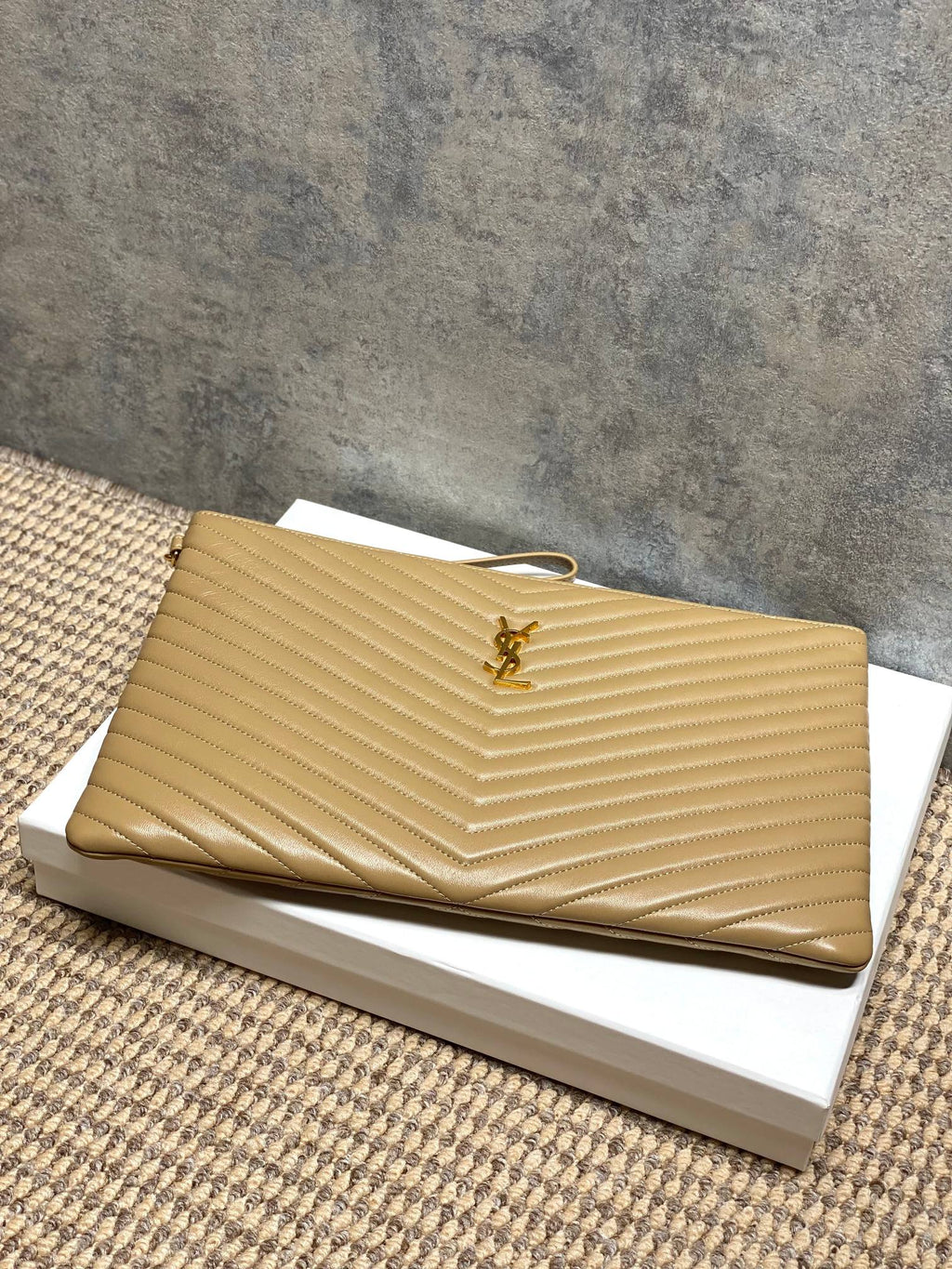 Gold quilted small bag with YSL logo and top zip, shown at an angle.