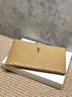Gold quilted small bag with YSL logo and top zip, shown at an angle.