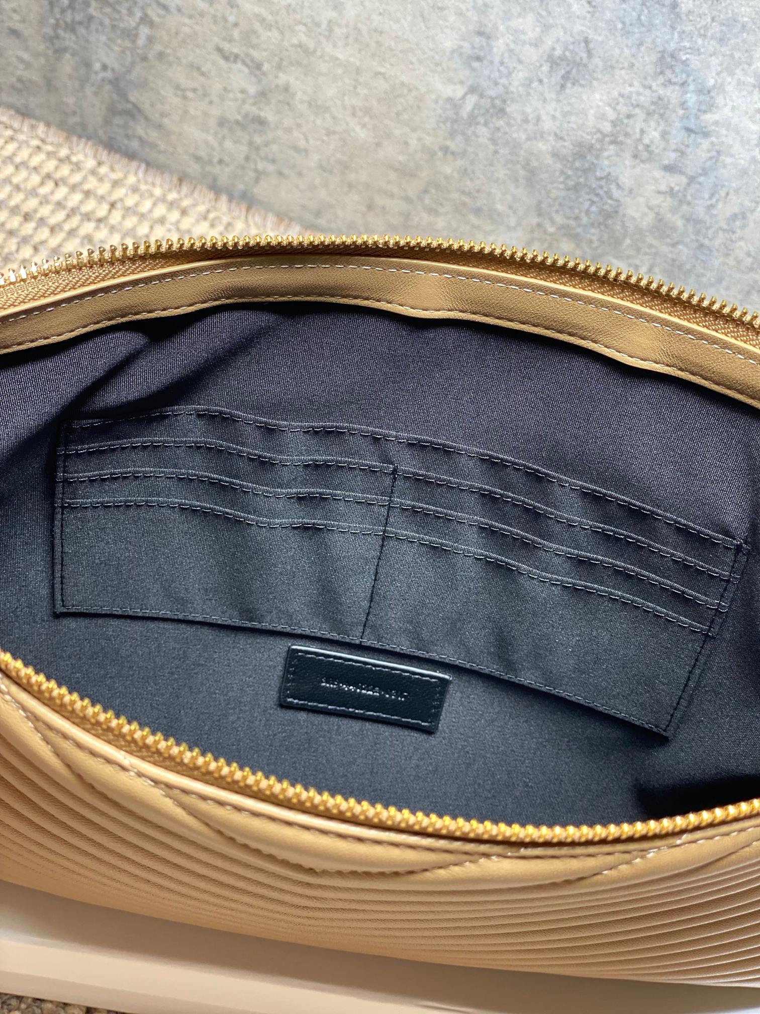 Dark fabric lining inside YSL small bag with stitched pocket and gold zipper edge.