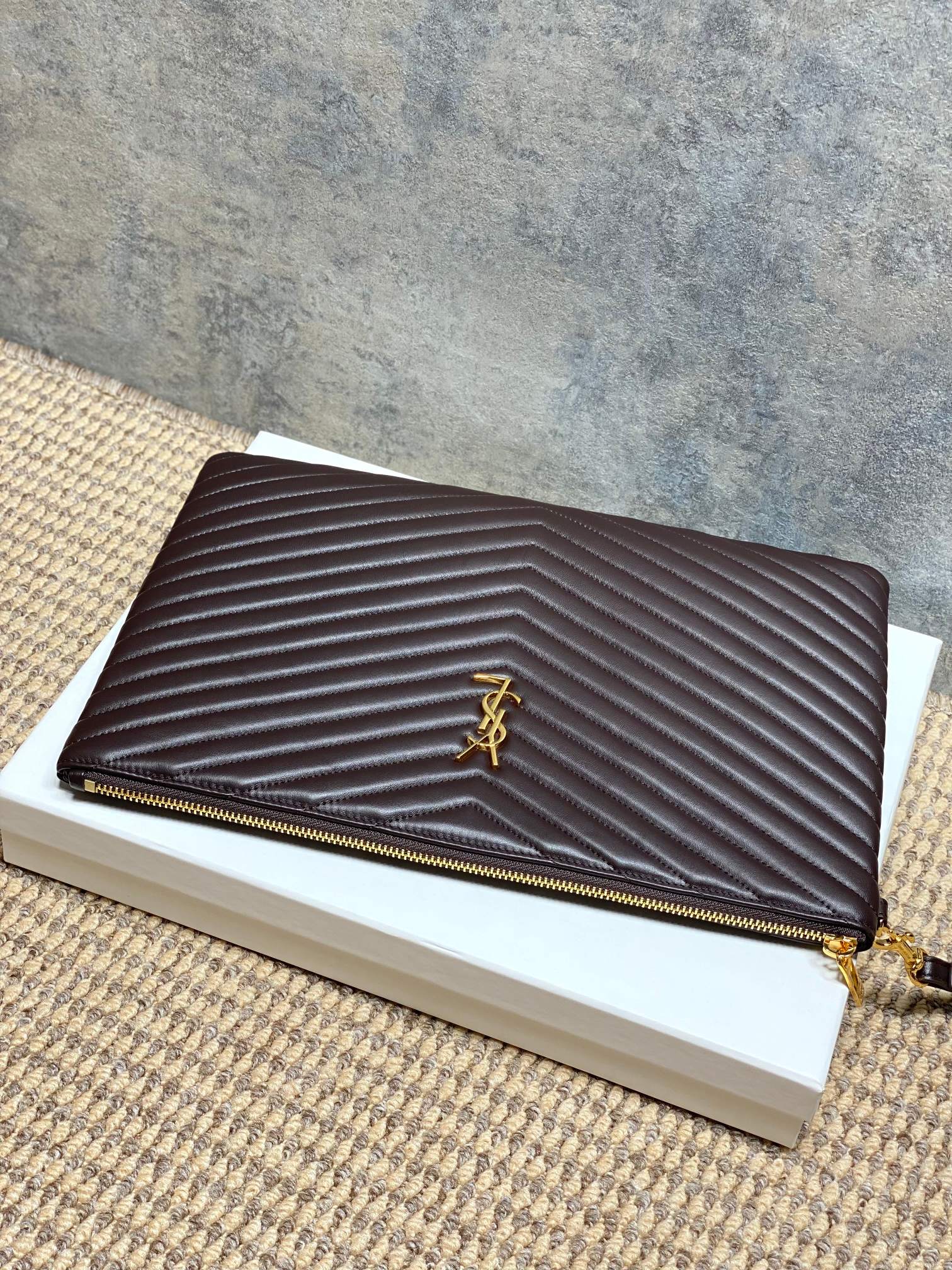 Dark brown quilted leather bag with gold zipper and chevron stitching