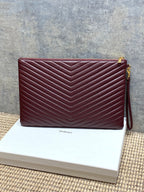 YSL burgundy quilted clutch with gold-tone hardware and wrist strap