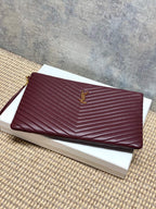 YSL burgundy quilted clutch with gold emblem and zip closure