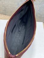 Open burgundy YSL bag with dark fabric lining and interior pocket
