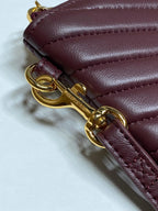 Gold-tone clasp and rings on burgundy leather strap