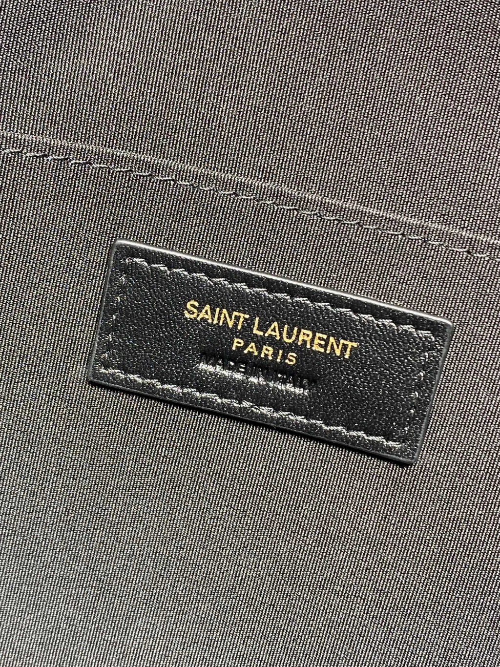SAINT LAURENT PARIS label on dark interior fabric of YSL bag