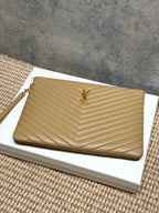 Tan quilted clutch bag with chevron texture and gold YSL logo on front